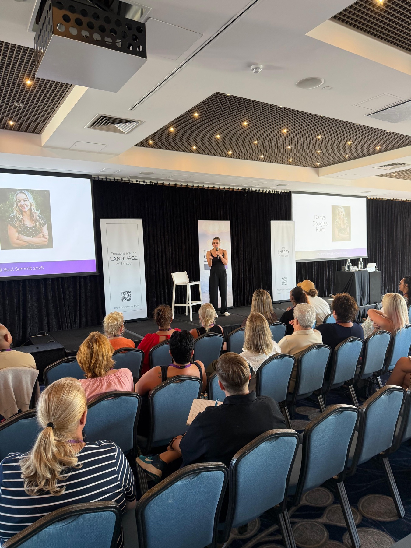 Danya on stage with a live crowd at Inspirational Soul Summit